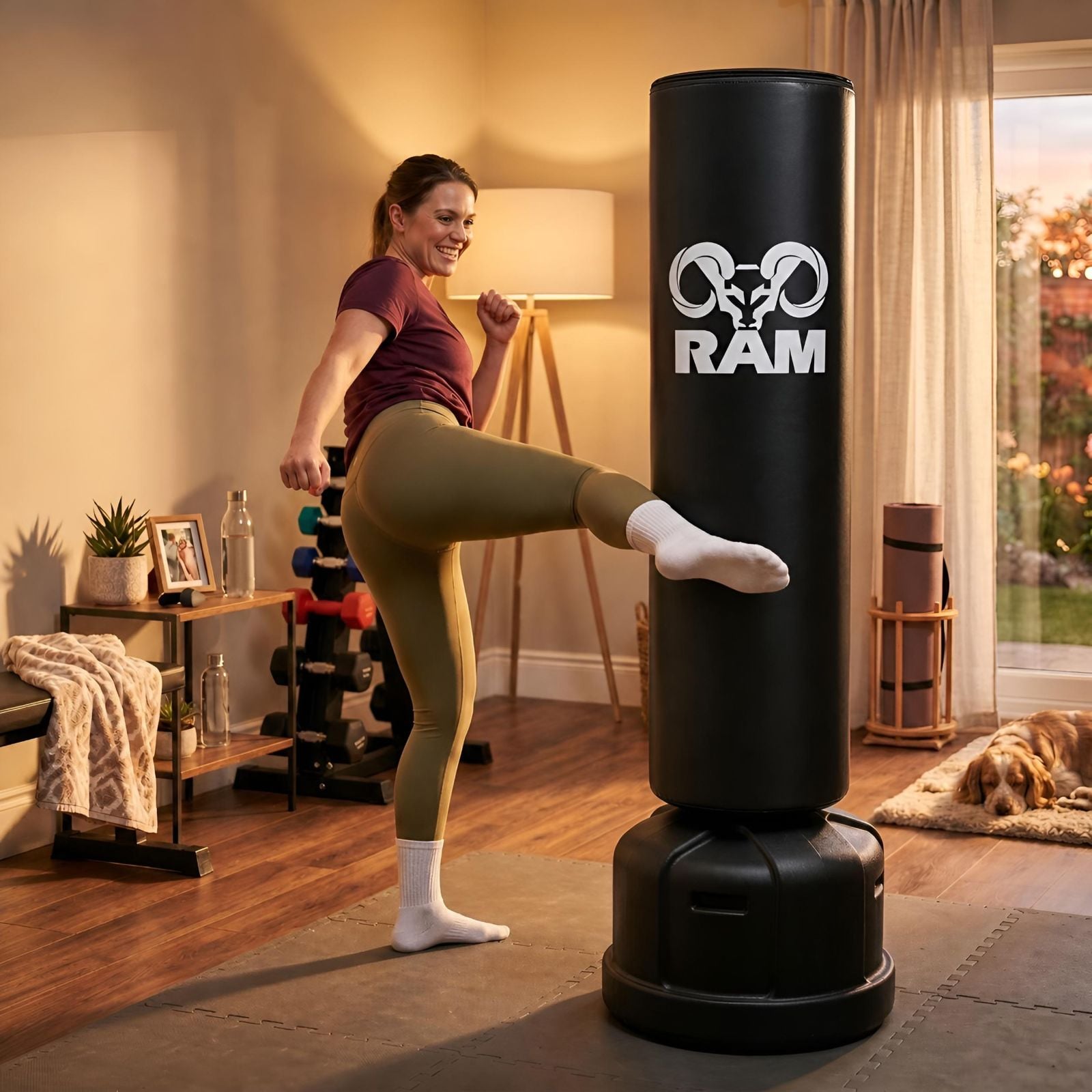 RAM O Bokspaal / Staande Bokszak - Zwart Jonge vrouw geeft een hoge trap tegen de RAM O vrijstaande bokspaal in haar thuisgym
