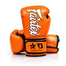 Vooraanzicht van oranje Fairtex bokshandschoenen, eentje staand en eentje liggend, de fxb-bg v2.