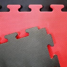 Detailopname van de puzzelrand en antislipprofiel van de Buy2Fight puzzelmatten in zwart en rood