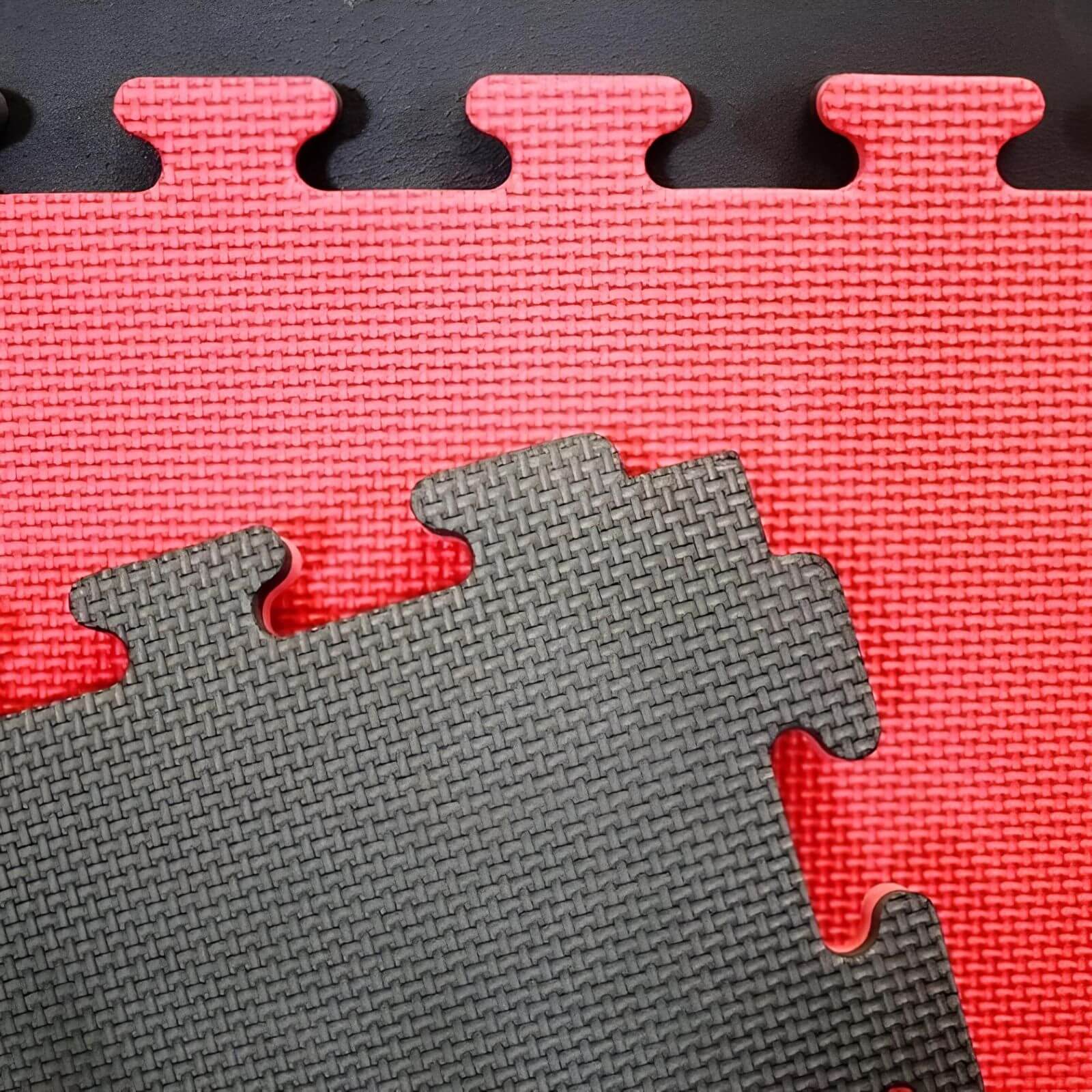 Puzzelmat / Vloermat 100 x 100 x 2,5 cm Rood–Zwart Detailopname van de puzzelrand en antislipprofiel van de Buy2Fight puzzelmatten in zwart en rood